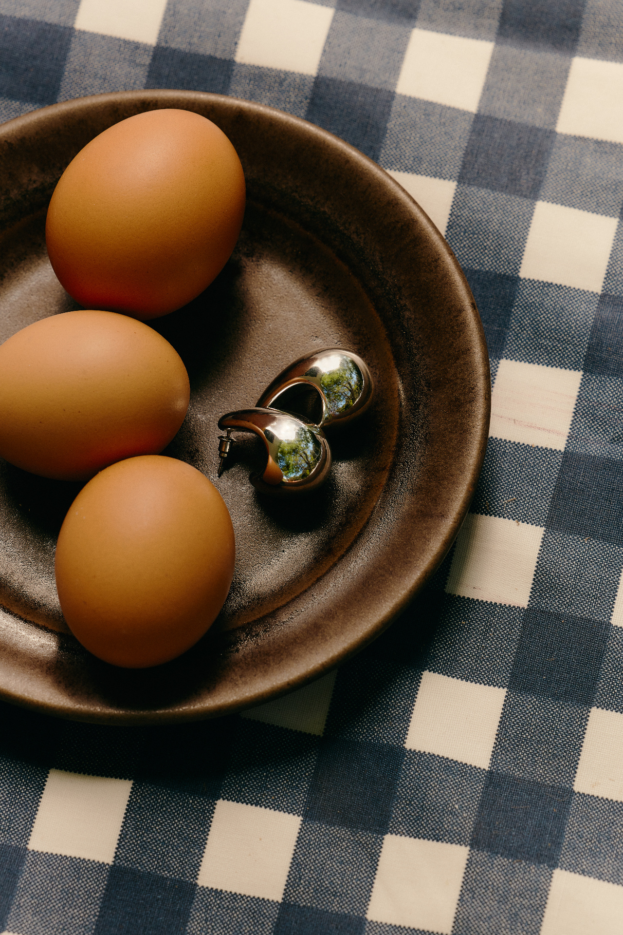 Heirloom tomatoes and eggs on a linen-draped table in warm morning light