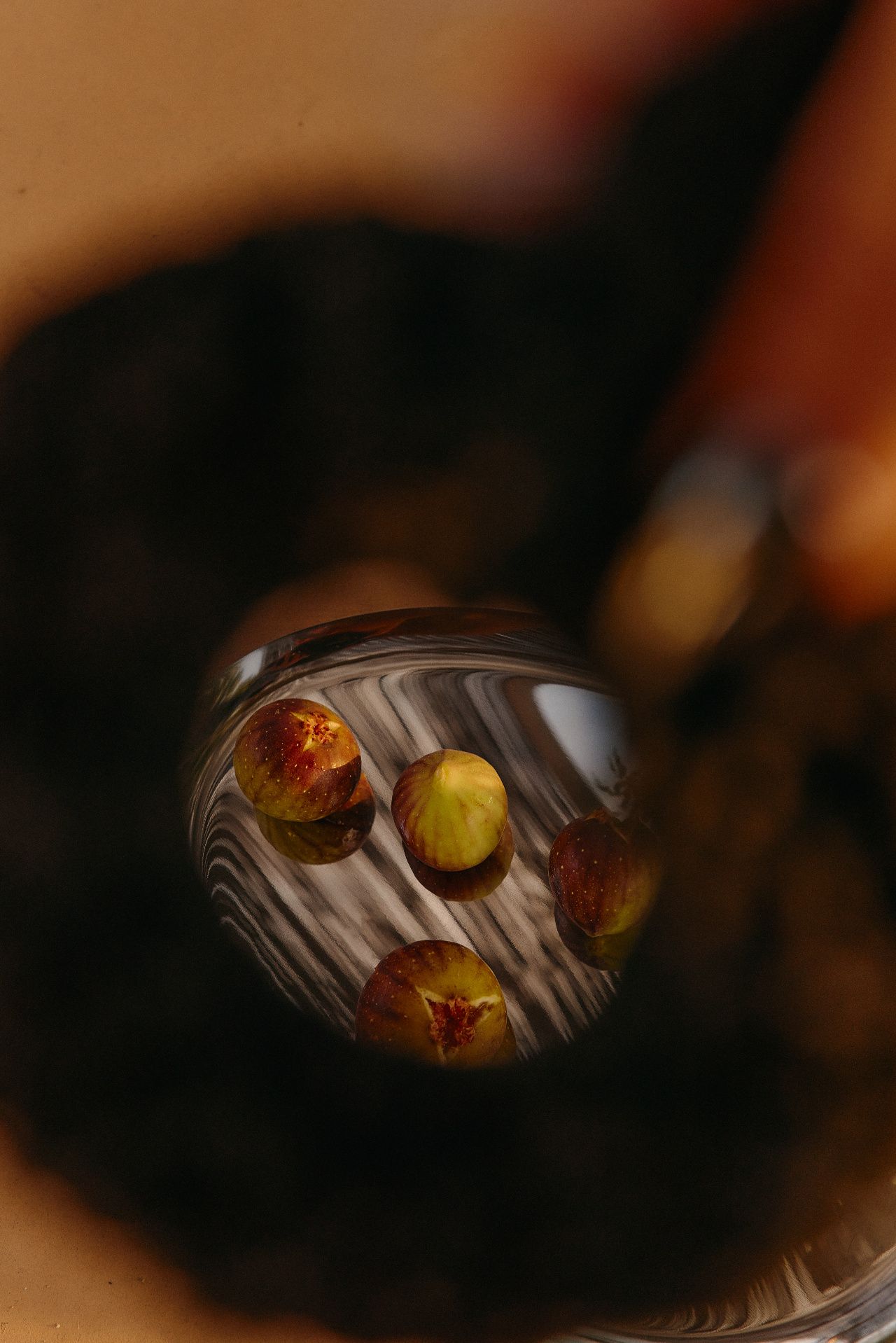 Figs seen through the base of a glass in warm afternoon light